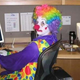 A clown looking at a computer screen.